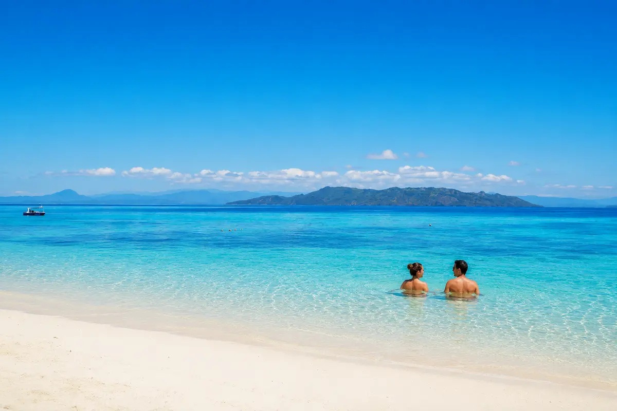 Couple swimming at Nosy Tanikely beach in Nosy Be Madagascar