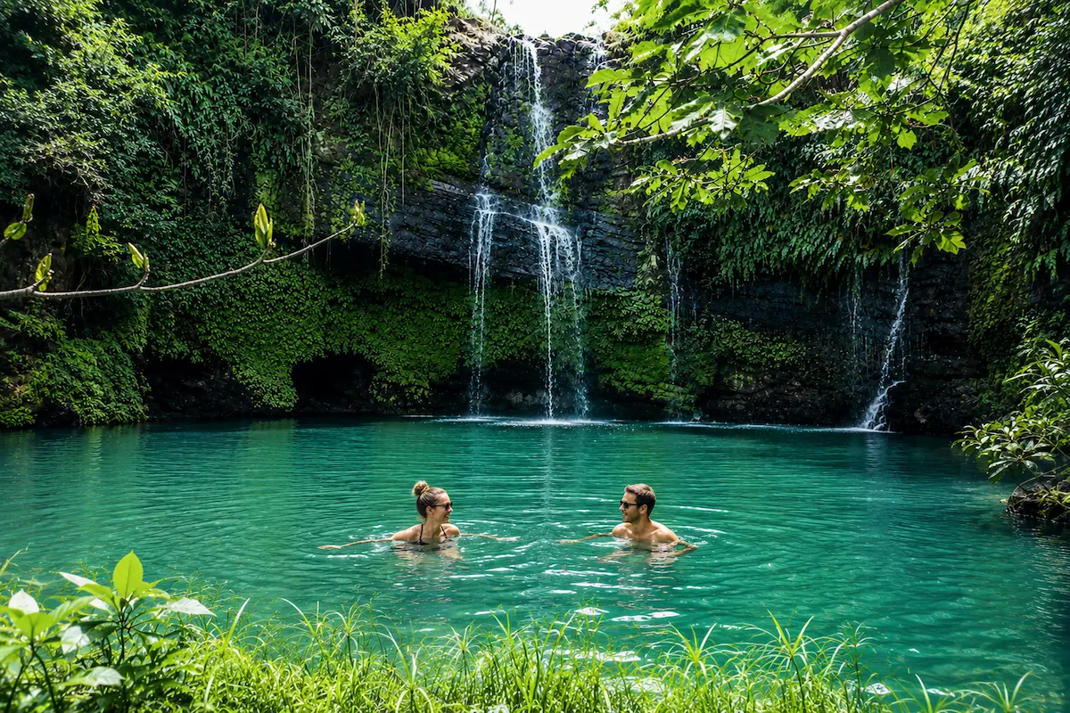 Tourist swimming at the Sacred Waterfall in Nosy Be, Madagascar