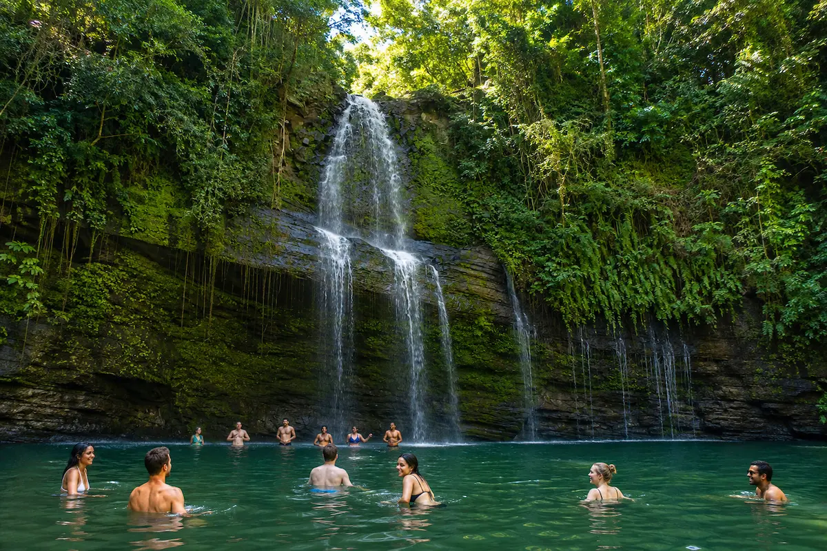 Tourists enjoying a waterfall swimming tour during Nosy Be Madagascar excursion