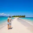Couple taking photos on Nosy Iranja sandbank tropical beach in Madagascar